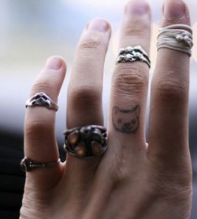 Rings on finger and cat tattoo on finger
