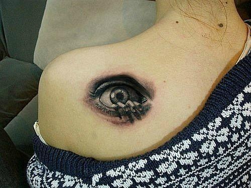 Scary hand and eye tattoo on shoulder