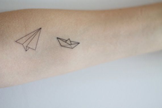 Ship and plane origami tattoo on arm