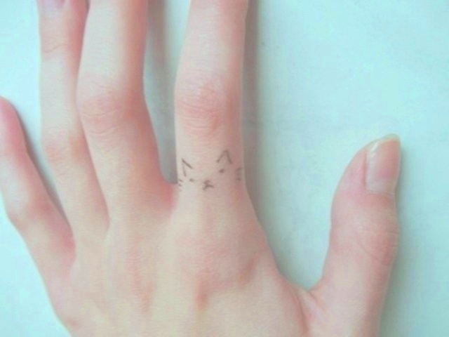 Simple angry cat tattoo on finger