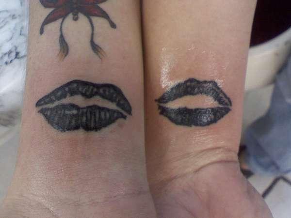 Simple black lips tattoo on arm