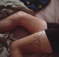 Simple black map tattoo on legs