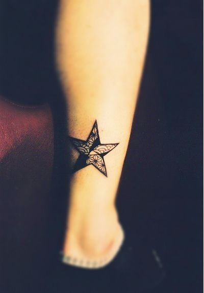 Simple black star tattoo on leg
