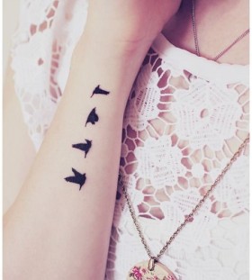 Small black birds tattoo on arm