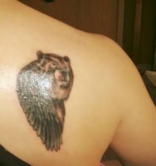 Small brown bear tattoo on shoulder
