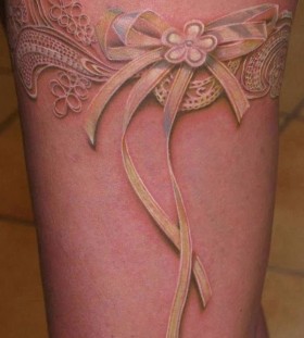 White flower and lace tattoo on leg