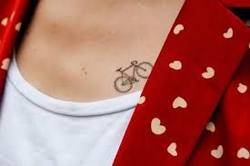 Women red jacket with heart and bicycle tattoo on arm