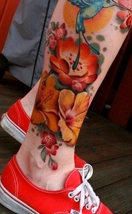 Yellow and red bird tattoo on leg