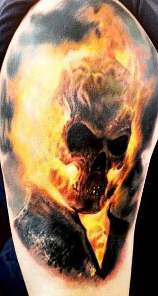 Yellow fire skull tattoo on shoulder
