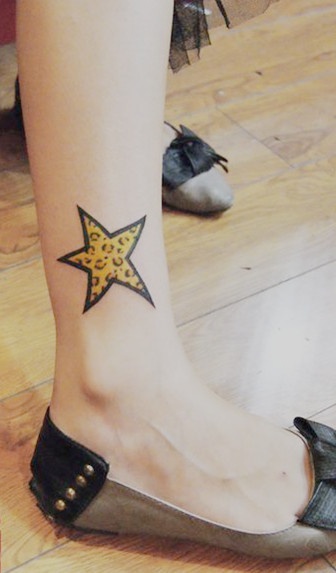 Yellow tiger star tattoo on leg
