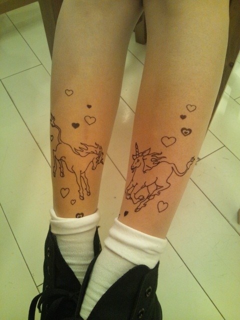 unicorn tattoo with hearts on legs
