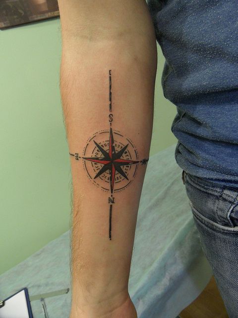 Black and red compass tattoo on arm