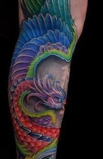 Blue, red, green peacock tattoo on leg