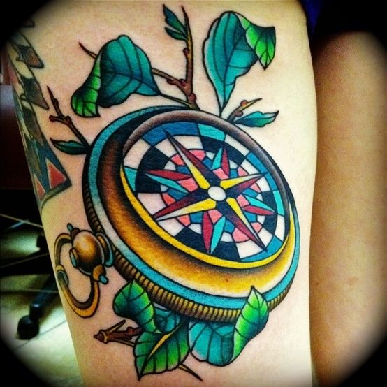 Colorful ornaments and compass tattoo on leg