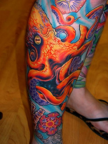 Colorful red octopus tattoo on leg