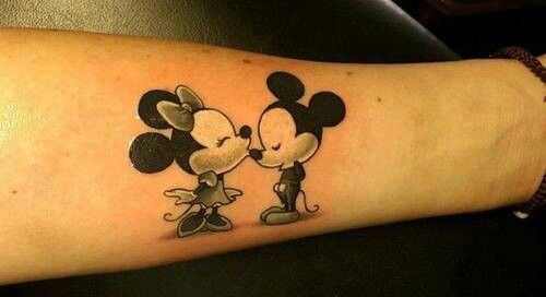 Couple kiss Mickey Mouse tattoo on leg