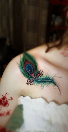 Green peacock style angel tattoo on shoulder