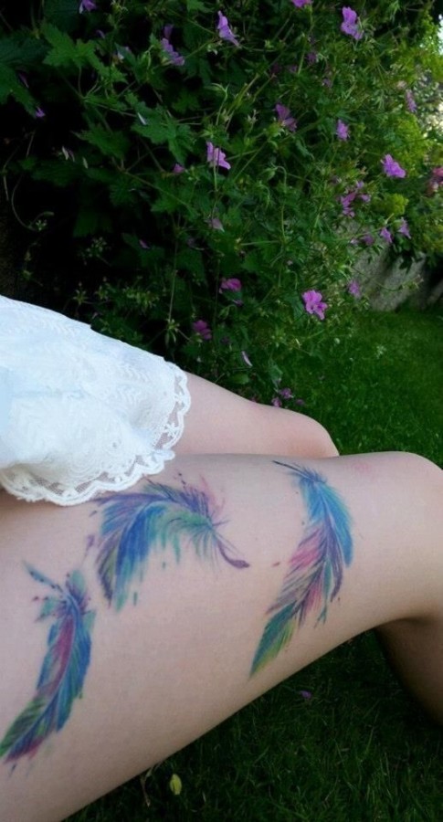 Red, blue, green peacock tattoo on leg