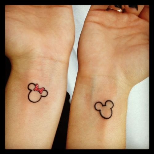 Red bow Mickey Mouse tattoo on arm