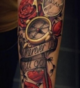 Red roses and lovely compass tattoo on arm