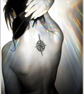 White nails and compass tattoo on back