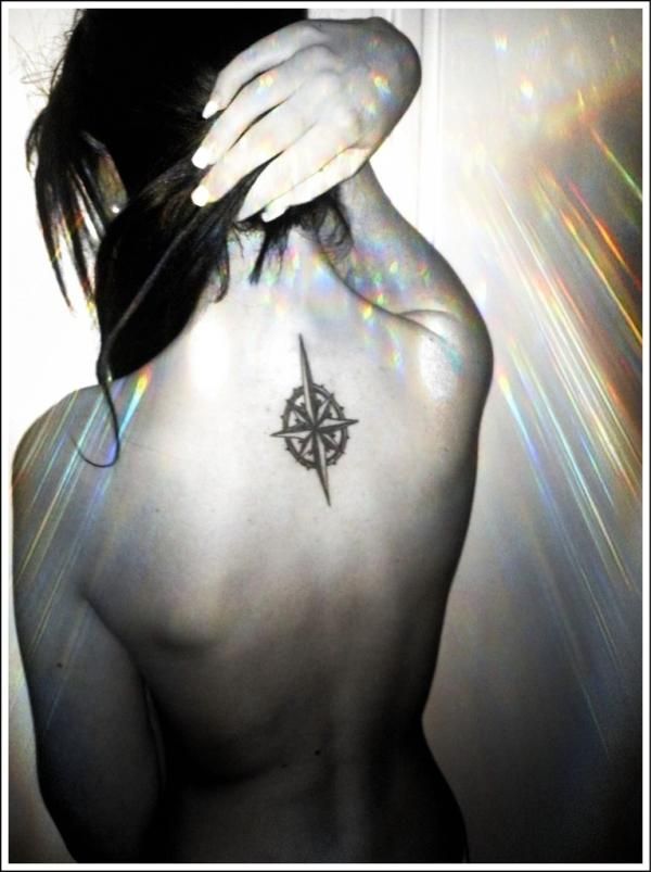 White nails and compass tattoo on back