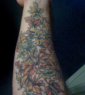multicolored autumn leaves tattoo on arm
