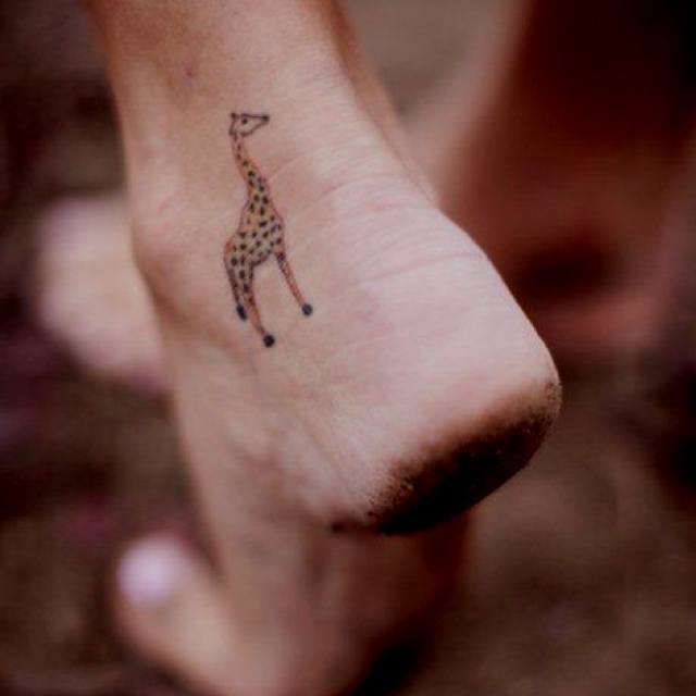 small giraffe tattoo on foot