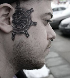 A ship's wheel face tattoo