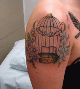 Birdcage and colourful flowers tattoo