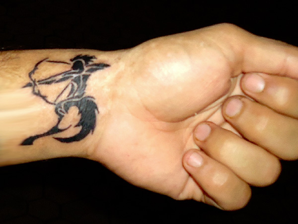 Black ink sagittarius wrist tattoo