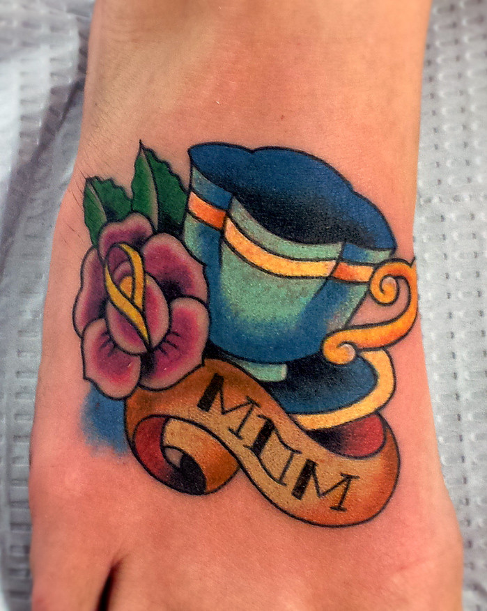 Blue teacup and flower foot tattoo