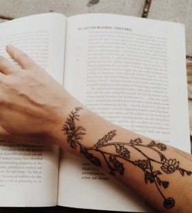 Book and plants arm tattoo