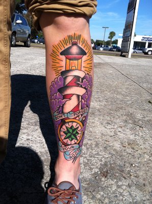 Coloured lighthouse leg tattoo