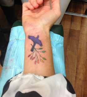 Colourful mockingbird wrist tattoo