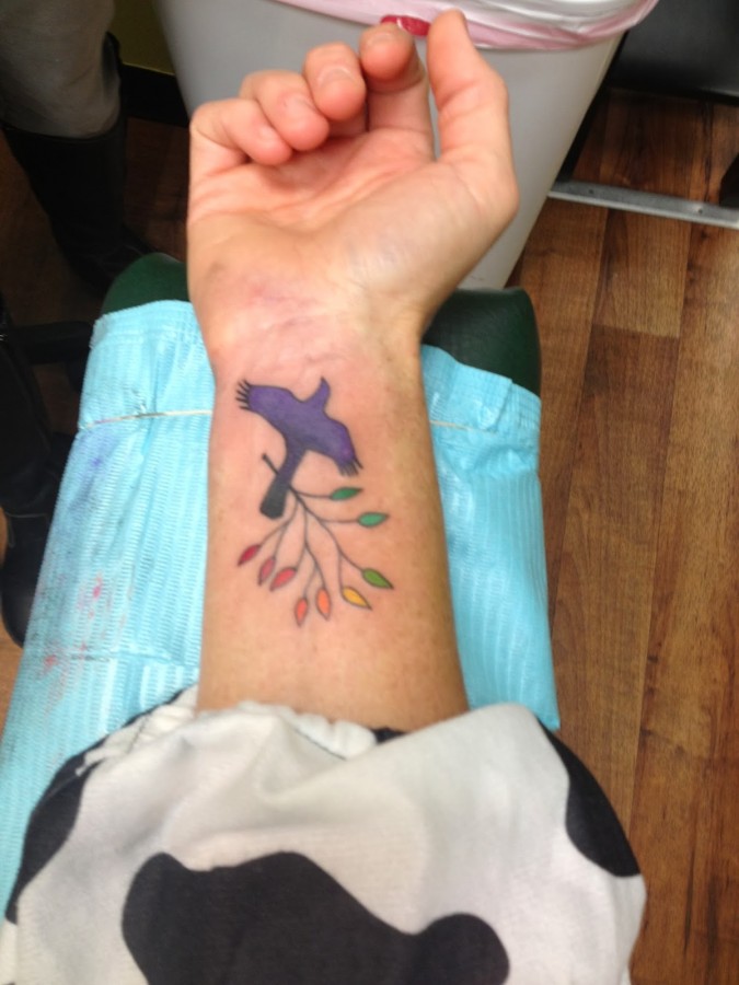 Colourful mockingbird wrist tattoo