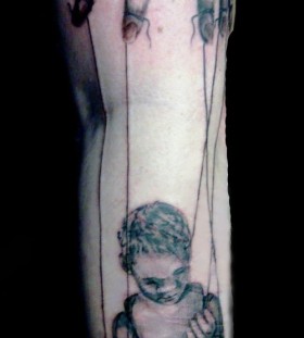 Creepy puppet leg tattoo