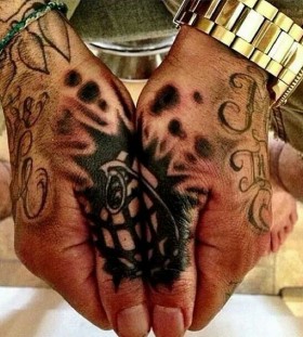 Grenade tattoo on thumbs