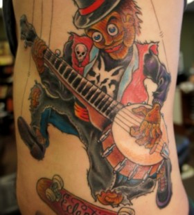 Guitar playing puppet tattoo