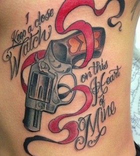 Gun and writing tattoo by Jon Mesa
