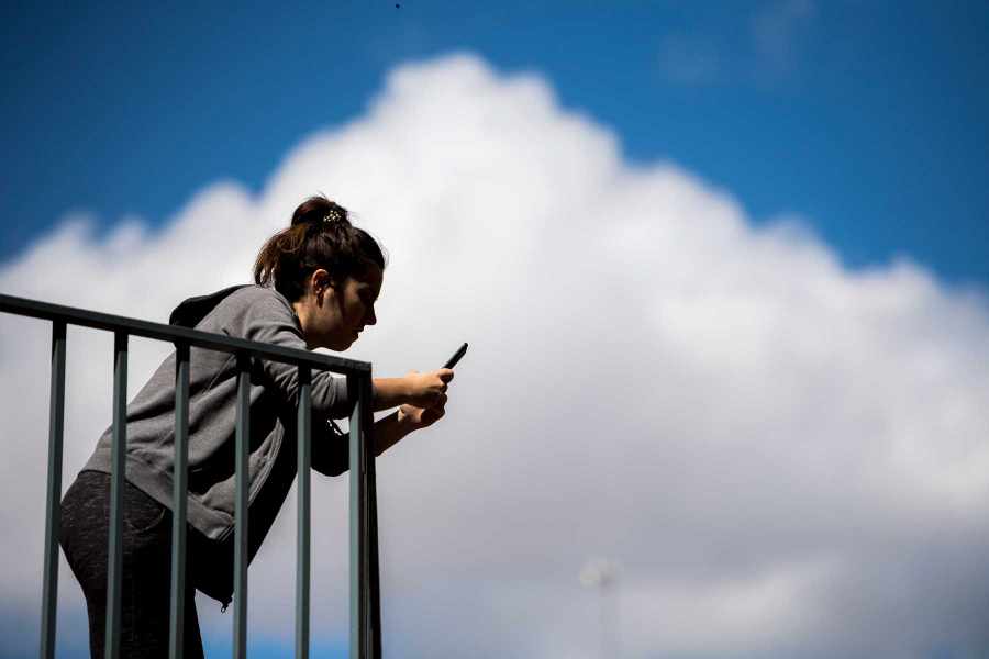 A woman using her smartphone on the balcony of her house