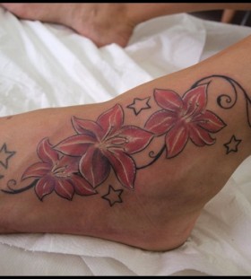 Lovely coloured flower ankle tattoo