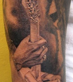 Man playing guitar tattoo by Xavier Garcia Boix