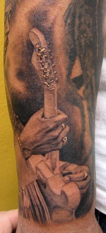 Man playing guitar tattoo by Xavier Garcia Boix