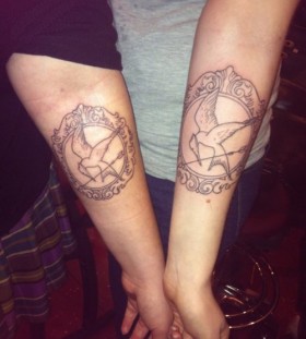 Mockingjay frame arm tattoo