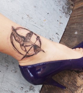 Mockingjay logo ankle tattoo