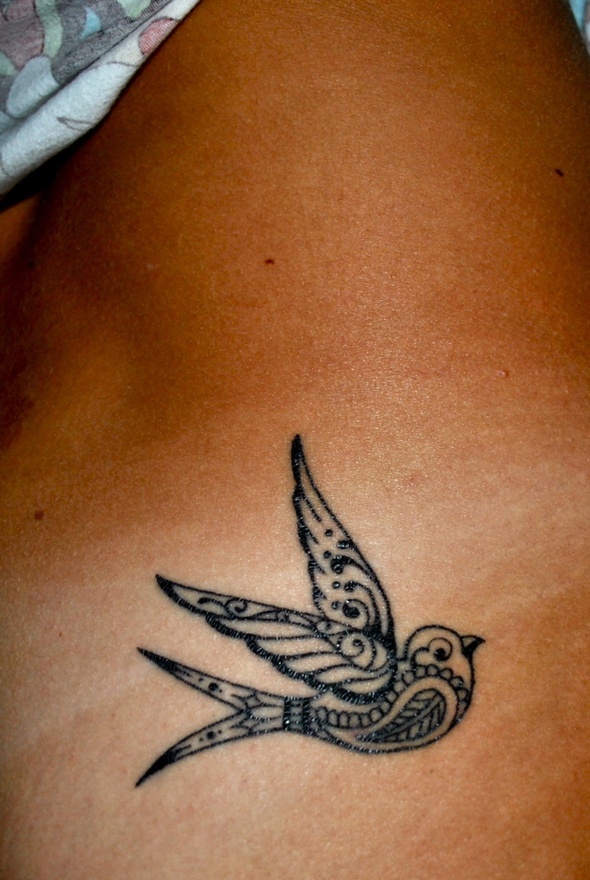 Ornamentally black tribal bird tattoo