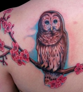 Owl on a tree branch tattoo