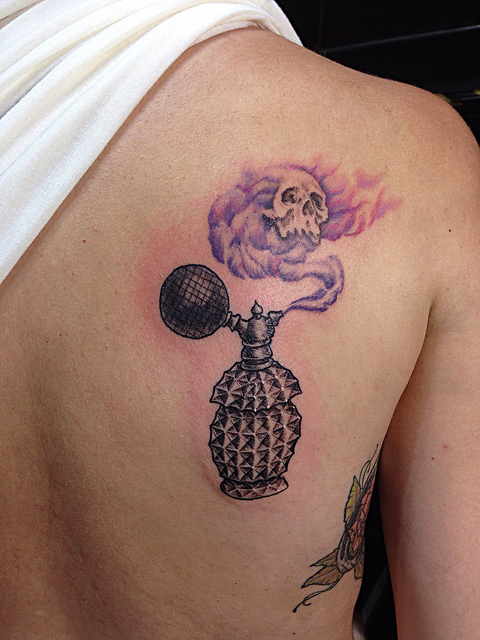 Perfume bottle and skull tattoo