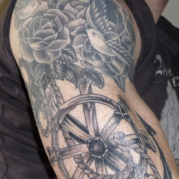 Roses and wheel arm tattoo